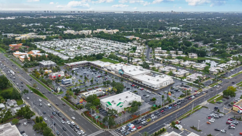 Aerial view of Keene Plaza in Largo, FL, with Sprouts, Dollar Tree, and a large parking lot at a busy road intersection.